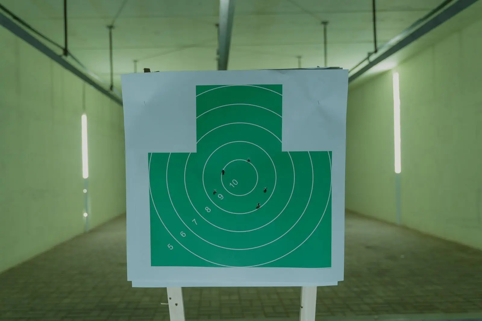 Green target with bullet holes at an indoor range